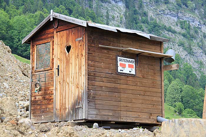 sehr luxuriöses Klo-Häuschen an einer Baustelle in Oberstdorf, mit Notfall Equipment an der Seite