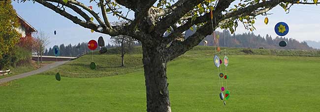 Sinnfreie Kunst aus Glas am Baum - oben die reifen, roten Äpfel - sieht einfach schön aus