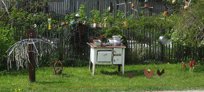 Kohleherd als Aussendeko in Oberried, mit echten Blechhühnern als Deko vor einem Bauerngarten