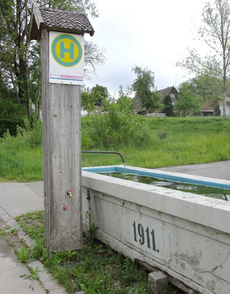 Teilsäule mit mehreren Funktionen- Zapfhahn Schlauchanschluss, Brunnen und  ÖPNV Wartestelle