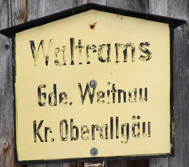Weitnau, Ortsteil Waltrams - das alte Ortsschild mit Wegekreuz kombiniert
