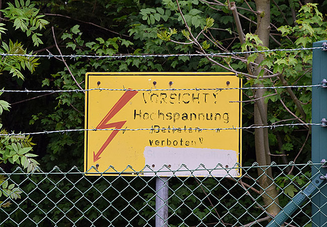 Dieser Gartenzaun ist Hochspannungsgesichert, zumindest auf dem Schild steht es.