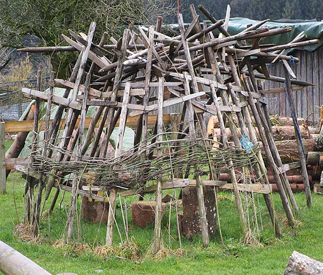 alte Huinzen zu einer kleine Hütte aufgebaut, die dann mit biegsamen Planzen einwachsen wird