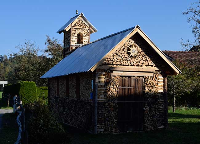 Holzkirche Amtzell (Holzstapel in Oberau) mit Kirchenglocke (Blumentopf)