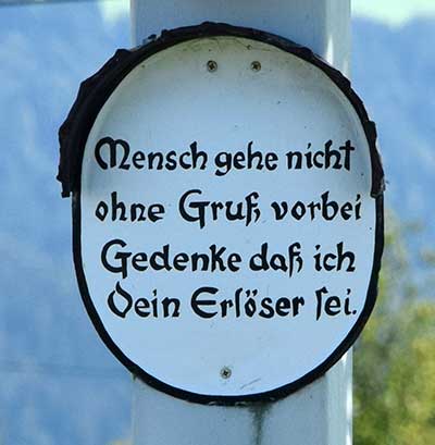 Früher war es üblich an jedem Kreuz stehen zu bleiben und einen Gruß zu entrichten. Heute gibt es zu viele davon. Der Text lautet: Mensch gehe nicht ohne Gruß vorbei, Gedenke daß ich dein Erlöser sei - Bux 2018 (Scheidegg)