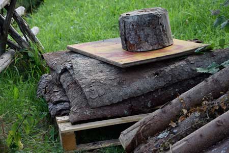Holzstaplergemeinde Trauchgau - Fichtenrinde für Holzer Hütte im Wald