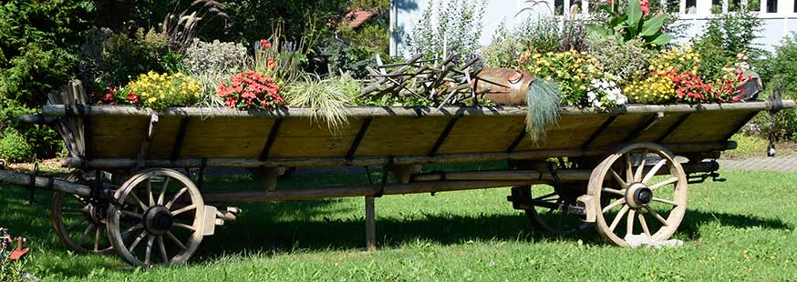 Sehr großer Leiterwagen schmückt den zentralen Platz im Dorf zusammen mit einer Sämaschine in Buchenberg