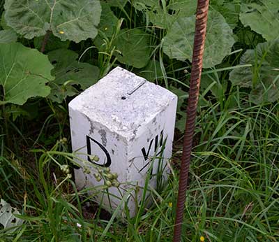 1844 - Vermessungsstein Grenze D an der Wertach mit der Brücke im Hintergrund 2019