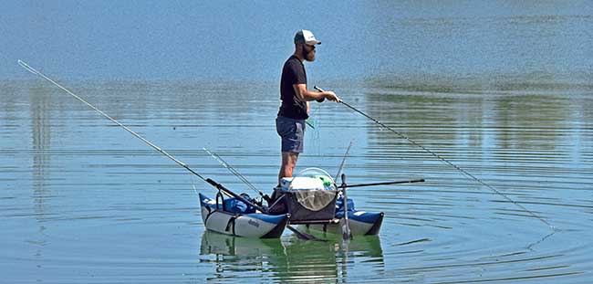 Angler mit minimalistschem Anglerboot auf dem Weissensee (Fischen 2020) - die Punkte auf dem Bild sind viele Schnaken, Mücken o.ä.