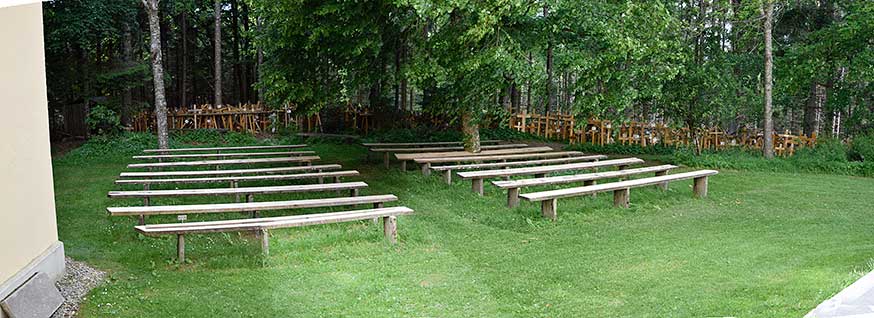 Gschnaidt - Vor dem Haupteingang der großen Kapelle stehen Bänke zur Andacht, dahinter viele hundert Sterbekreuze aus Holz