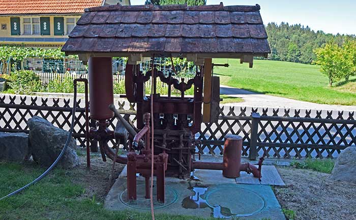 Güllepumpe umgebaut zu einer Wasserpumpe mit Elektroantrieb für die Gartenbewässerung auf einer ehemaligen Klärgrunbe, die zum Regenauffangbehälter umgebaut wurde. Mit Transmissionsantrieb