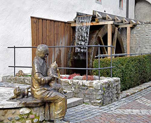 Wassermühle mit funktionierendem Wasserrad am Stadtmuseum Eselmühle in Wangen. ImVordergrund Denkmal der letzten Besitzerin Maria Neff